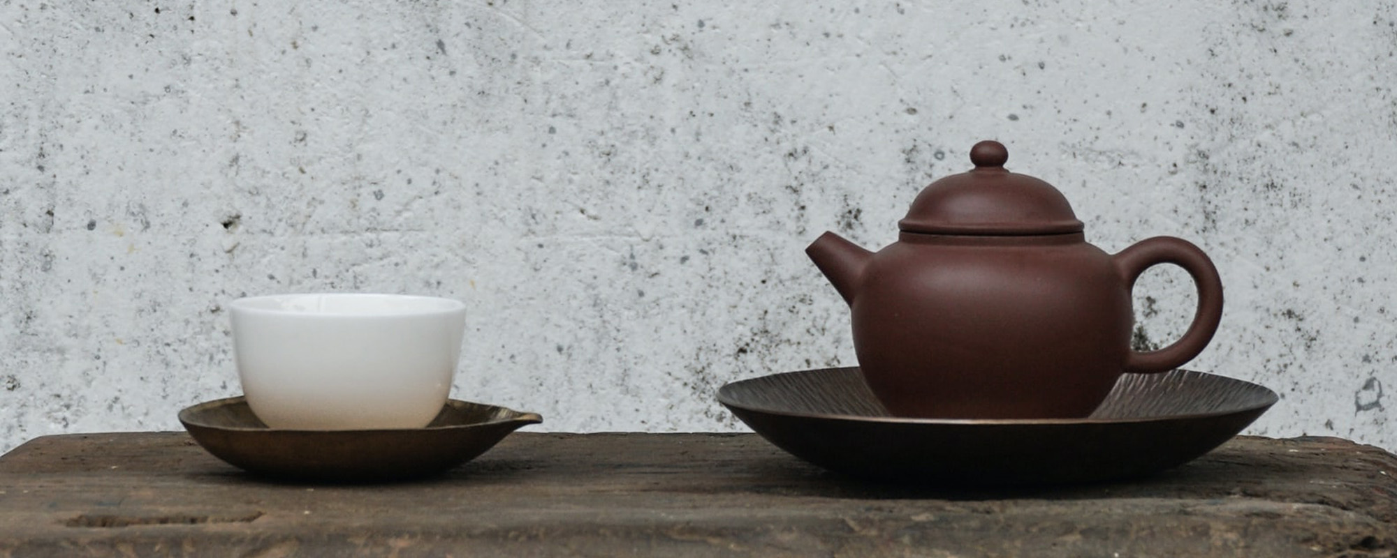 Teekanne und Teetasse auf einem Holztisch